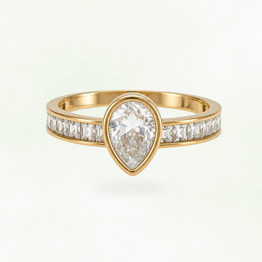 Gold-tone stainless steel ring with a pear-shaped clear stone and squarecut stones along the band