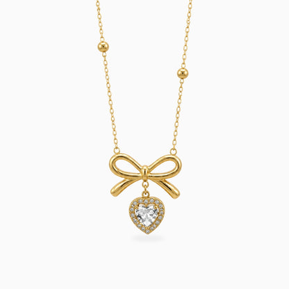 Gold-tone stainless steel necklace with a bow and a heart-shaped clear stone drop