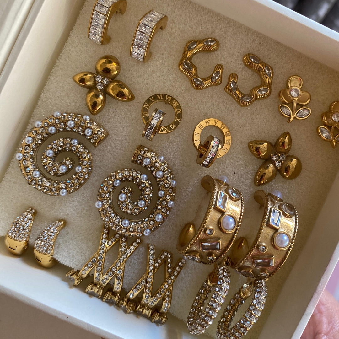 Close-up of small clear stones on a chunky gold-tone stainless steel huggie hoop