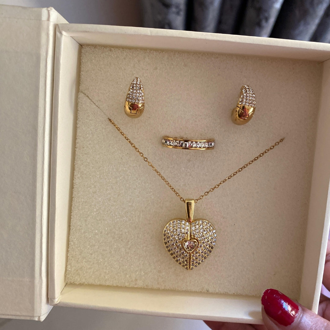  Close-up of a clear stone covered heart pendant with a small textured flower charm