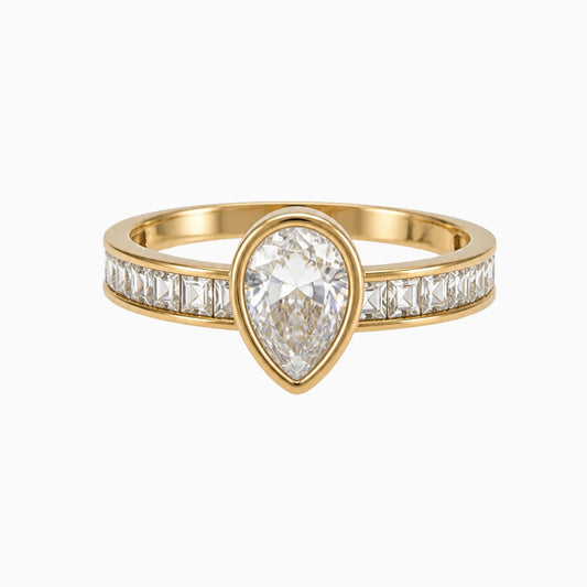 Gold-tone stainless steel ring with a pear-shaped clear stone and squarecut stones along the band