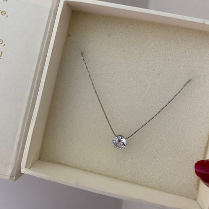 Close-up of a single round clear stone on a fine silver-tone stainless steel necklace