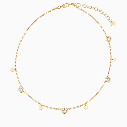 Gold-tone stainless steel station necklace with round clear stones, small discs and an extender chain